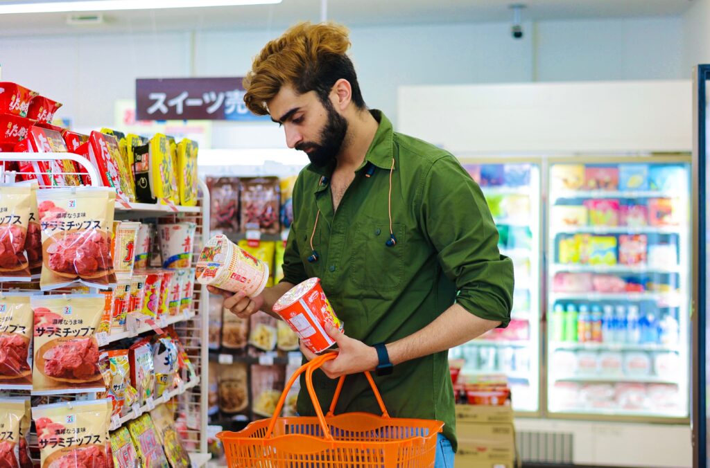 persona comparando productos en el supermercado antes de decidir cual comprar.